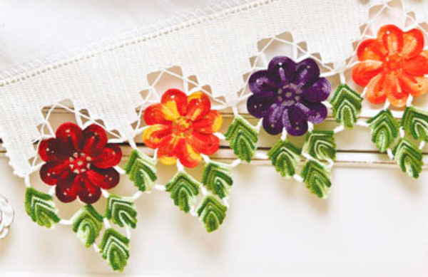 Bico de crochê com flores coloridas no pano de copa