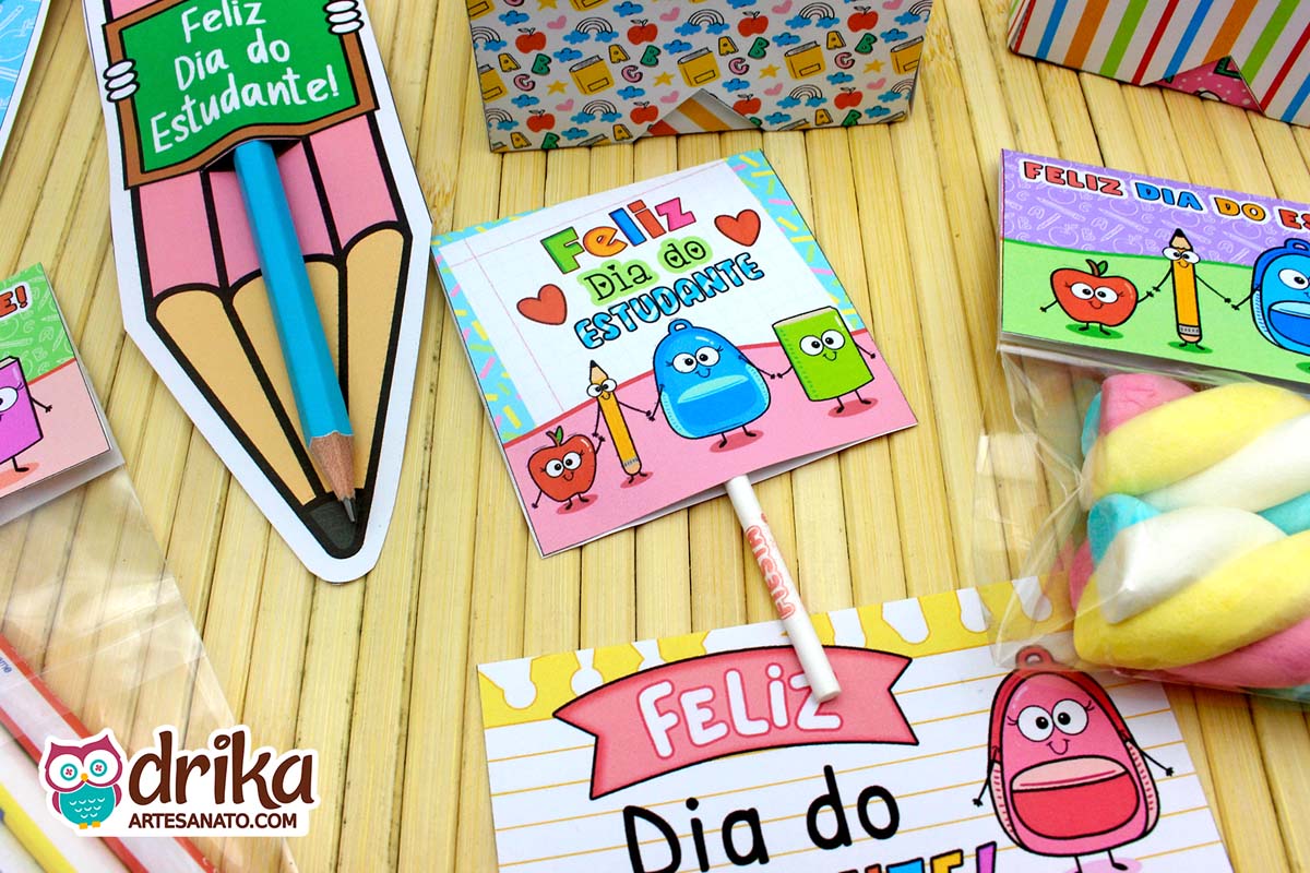 Capinhas de pirulito do Dia do Estudante com desenhos de lápis, maçã, mochila e livro em estilo cartoon sobre mesa de madeira.