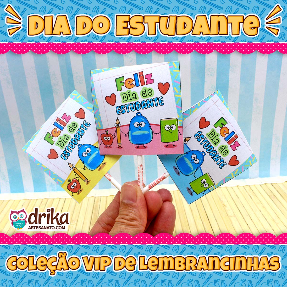 Mão segurando três pirulitos com capinhas temáticas do Dia do Estudante em frente a fundo azul listrado.