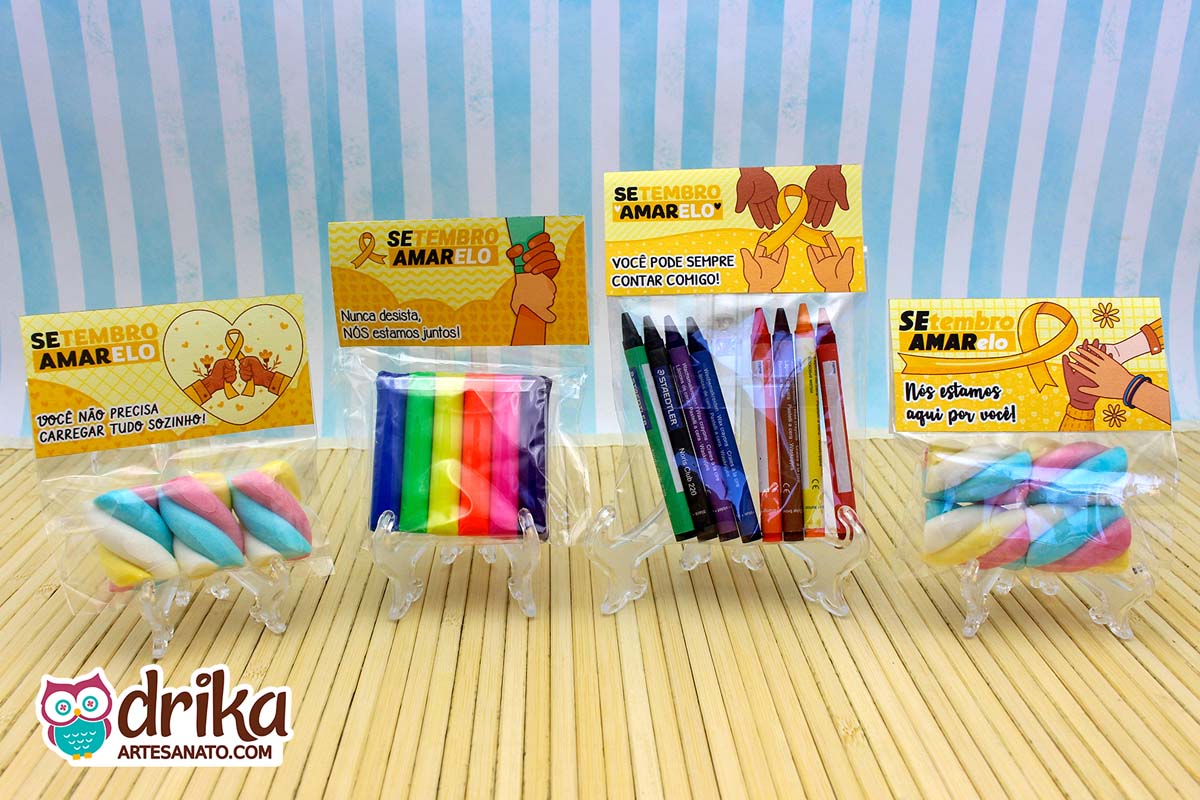 Quatro lembrancinhas Setembro Amarelo com lapelas e doces/giz em suportes transparentes sobre fundo azul