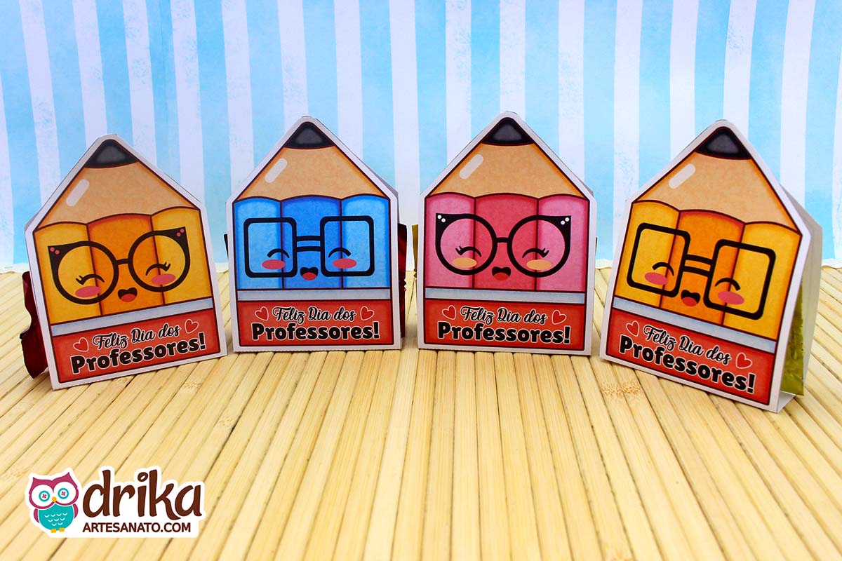 Quatro porta-bombons lápis cute lado a lado, em rosa, azul e amarelo, com mensagem "Feliz Dia dos Professores".