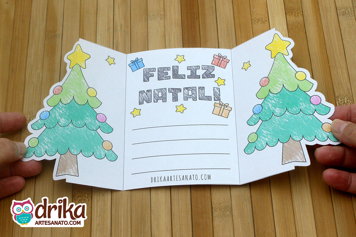 Cartão de Natal interativo aberto, mostrando árvores decoradas nas laterais, mensagem "Feliz Natal" e espaço para mensagem pessoal