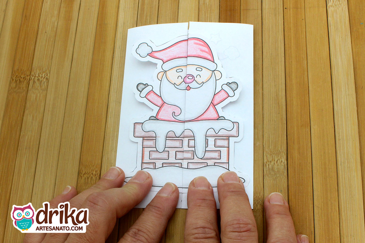 Cartão interativo de Natal fechado com desenho do Papai Noel saindo da chaminé, com detalhes em rosa e vermelho