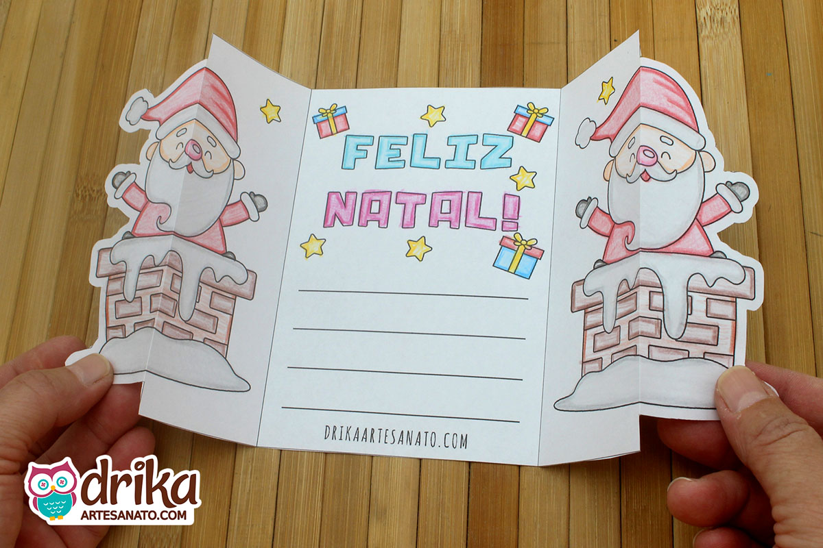 Cartão de Natal aberto com Papai Noel na chaminé, mensagem "Feliz Natal", estrelas, presentes e linhas para mensagem pessoal