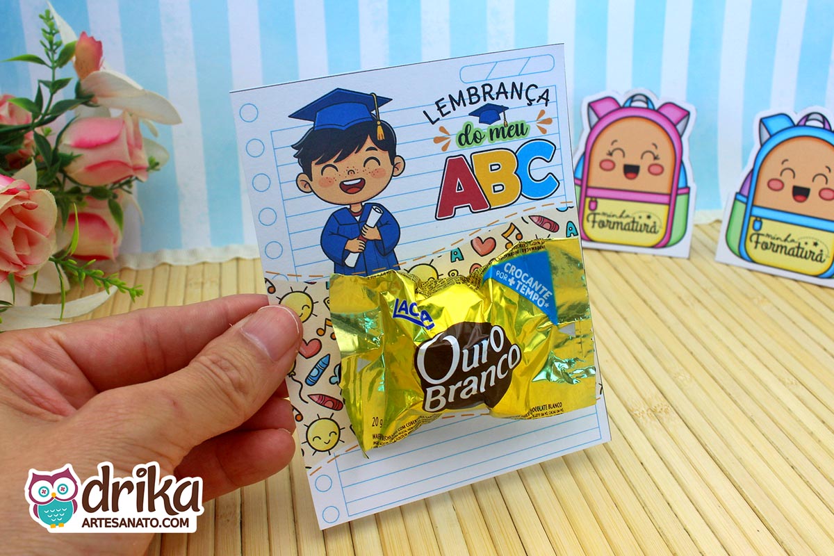 Close do cartão porta-bombom Formatura ABC com menino de cabelo preto e bombom Ouro Branco.