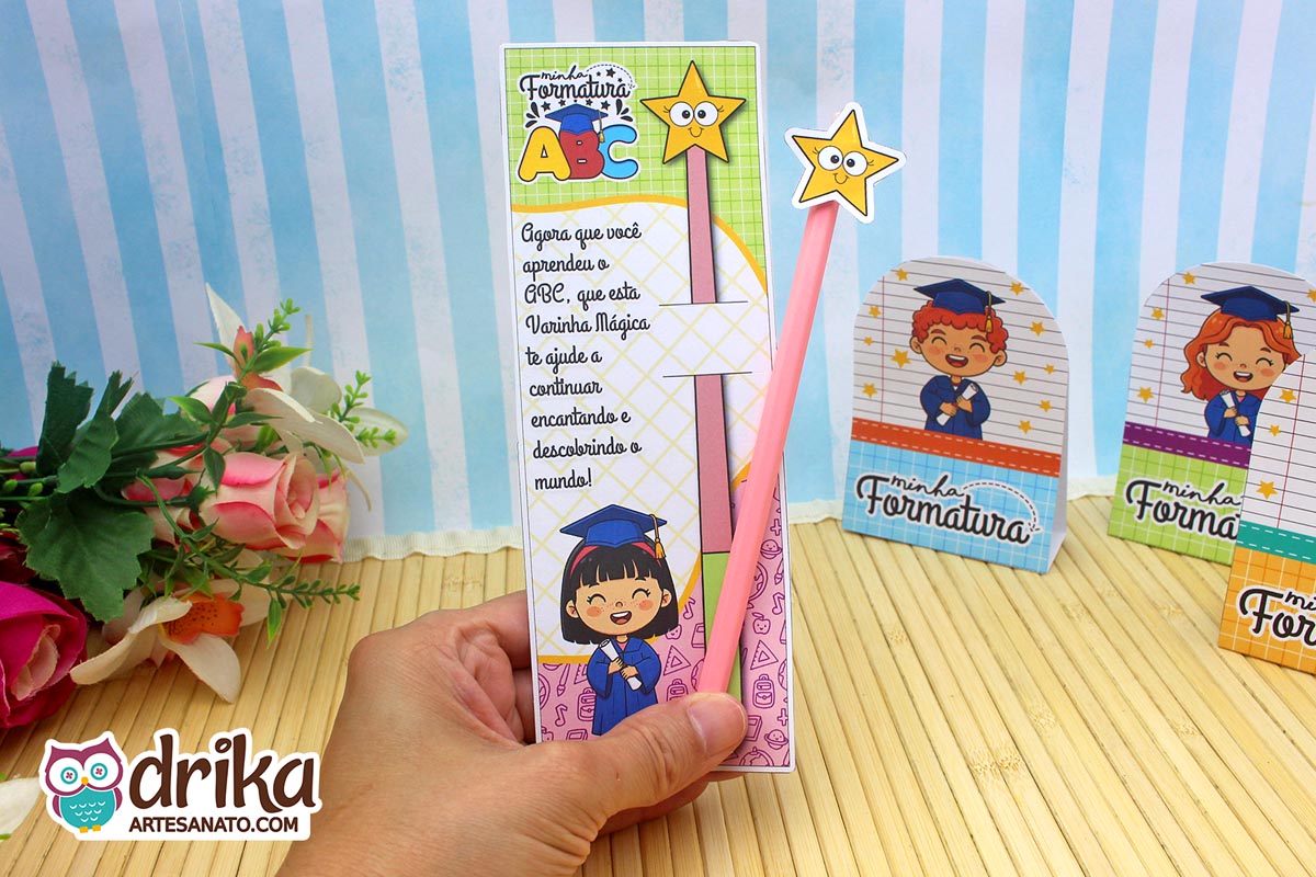 Cartão porta-lápis formatura ABC com menina de cabelo preto liso e lápis rosa sendo segurado por uma mão.
