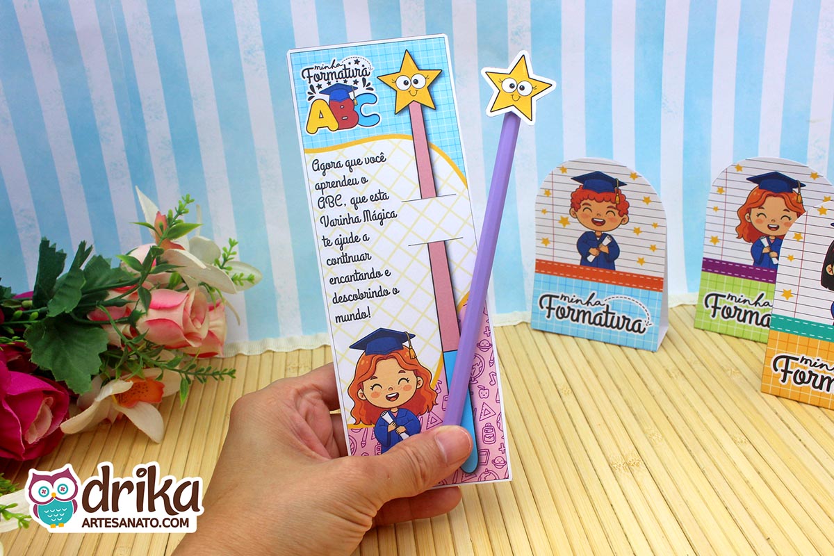 Cartão porta-lápis formatura ABC com menina ruiva e lápis roxo sendo segurado por uma mão.