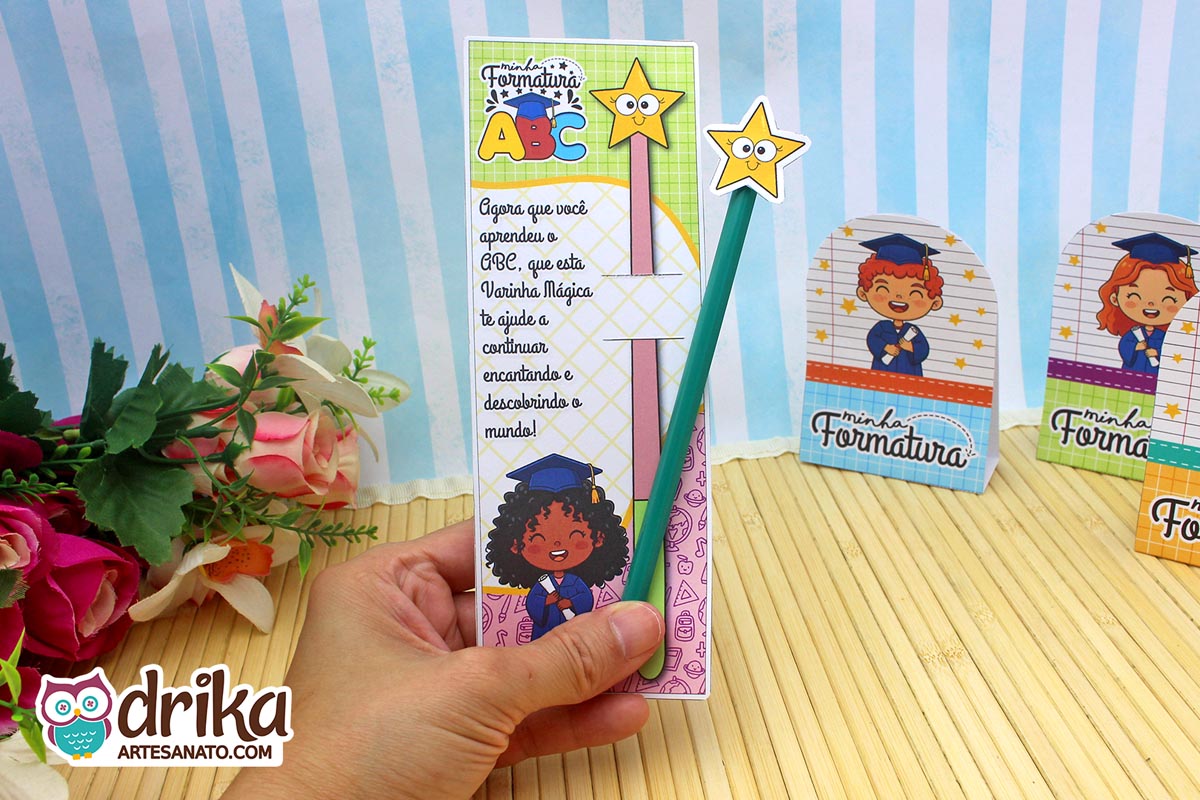 Cartão porta-lápis formatura ABC com menina de cabelo crespo e lápis verde sendo segurado por uma mão.