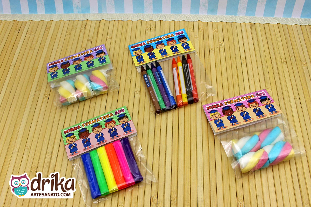 Quatro lembrancinhas de formatura ABC com lapelas de diferentes tons de pele, saquinhos com marshmallow, giz de cera e massinha.