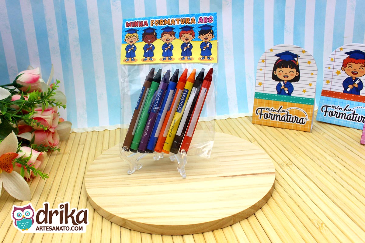 Saquinho transparente com giz de cera fechado com lapela de formatura ABC em tons de azul e amarelo.