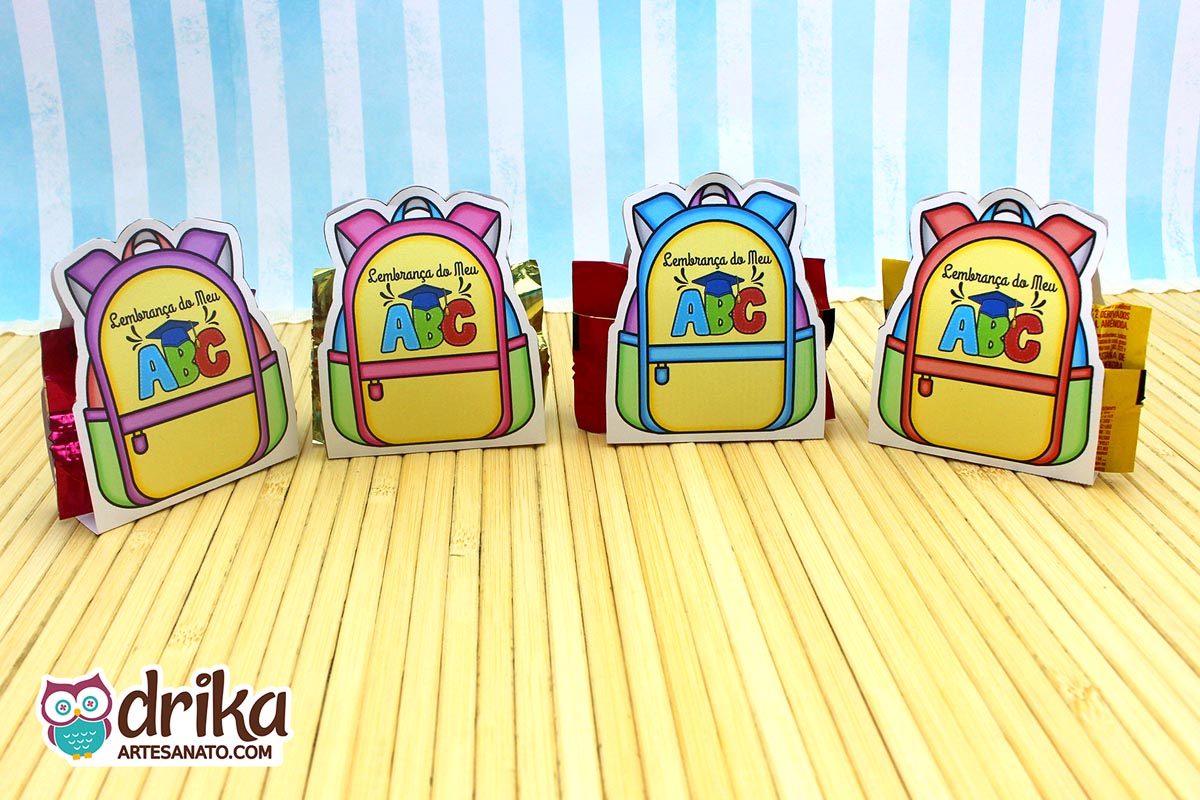Verso de quatro mochilas porta-bombom de formatura ABC com mensagem "Lembrança do Meu ABC" e espaço para dedicatória.