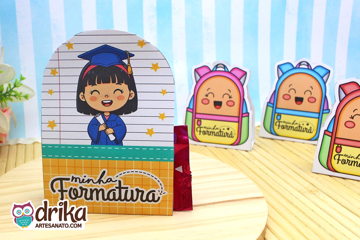 Porta-bombom Formatura ABC com menina de cabelo preto, beca azul e capelo, segurando diploma em fundo de caderno com estrelas amarelas