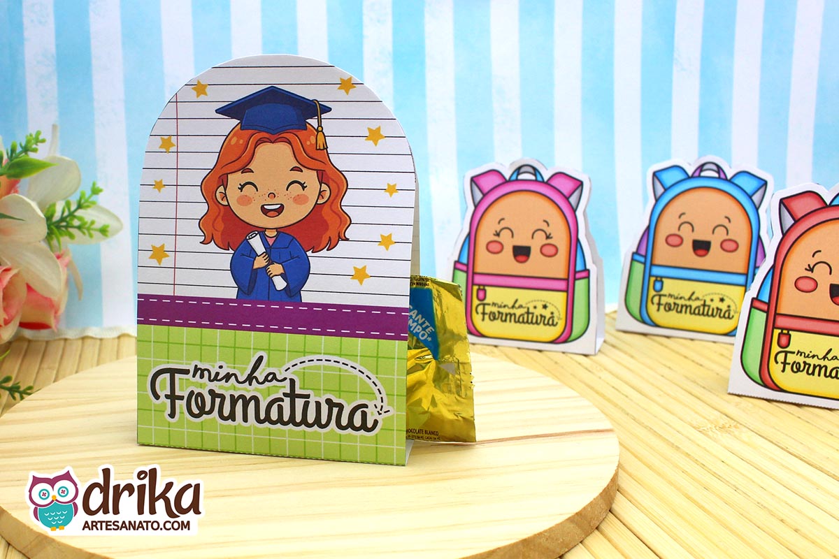 Porta-bombom Formatura ABC com menina ruiva, beca azul e capelo, segurando diploma em fundo de caderno com estrelas amarelas