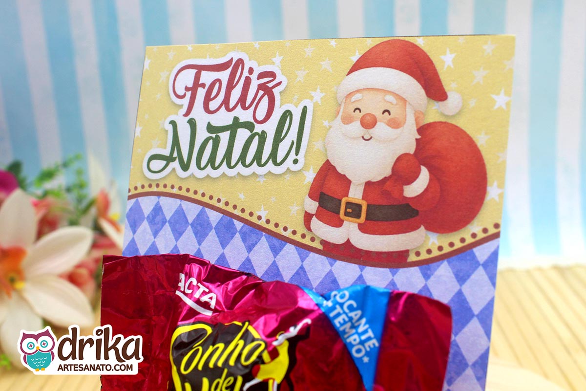Close do cartão porta-bombom de Papai Noel com bombom, destacando o desenho do Papai Noel.