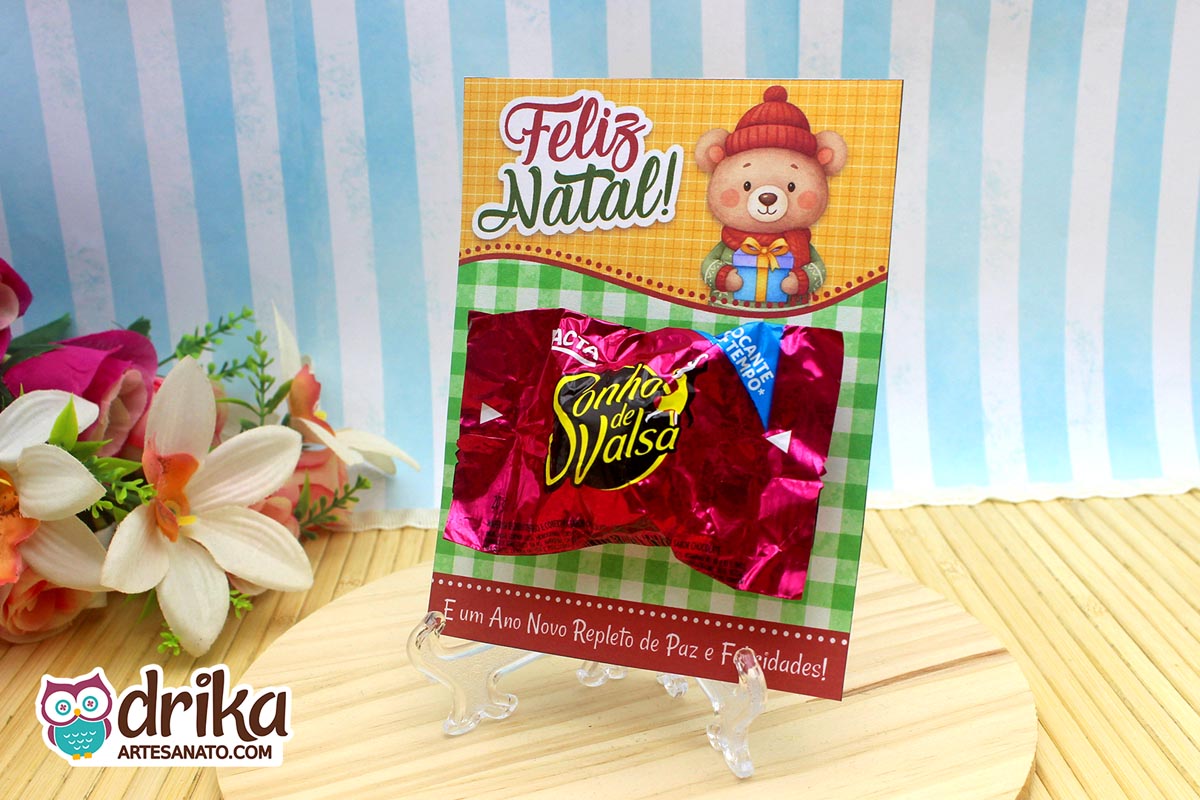 Cartão porta-bombom de Natal com urso e bombom Sonho de Valsa fixado, em suporte transparente.