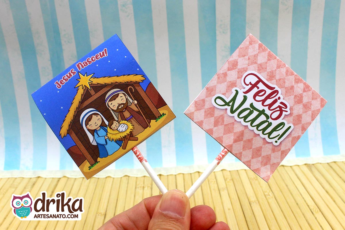 Capinhas de pirulito lado a lado: frente com a Natividade e verso com "Feliz Natal" em fundo xadrez