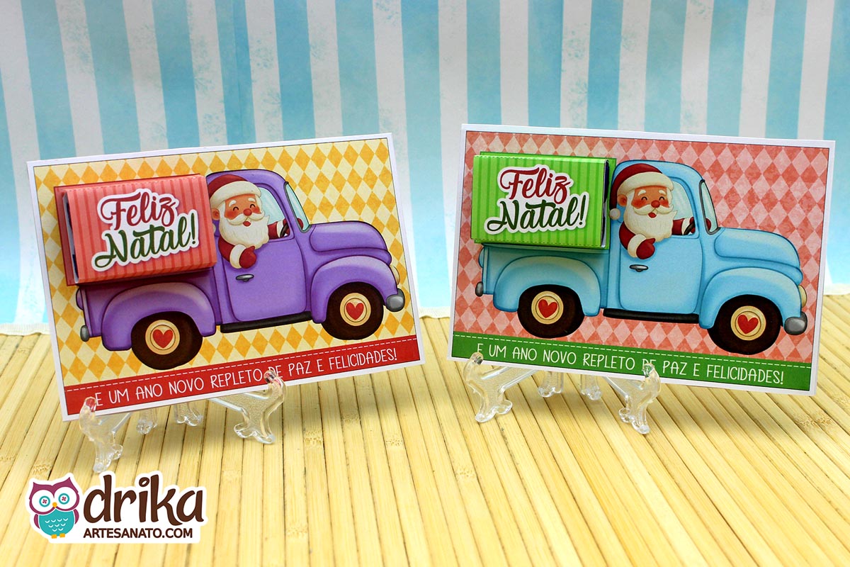 Dois cartões porta-bis de Papai Noel em caminhonetes, um roxo e outro azul, com chocolates Bis