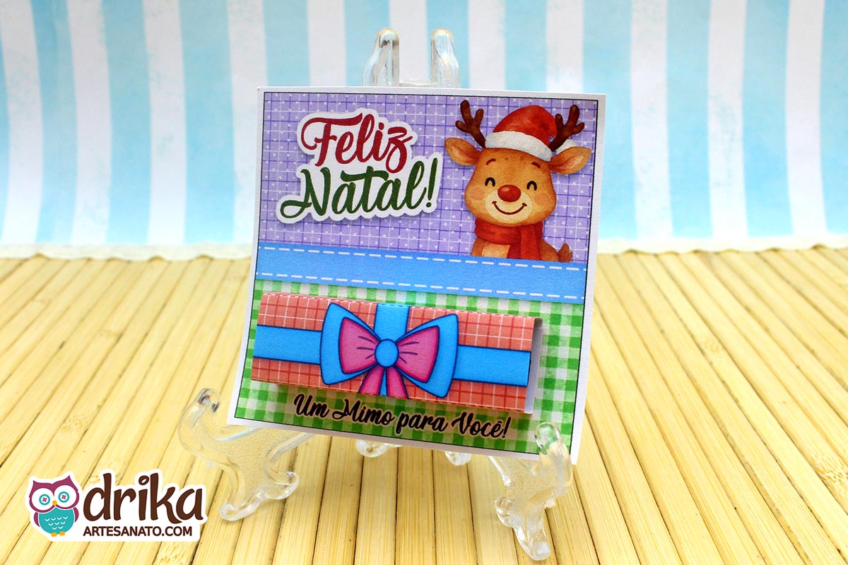 Cartão porta-bis de Natal com rena fofa e "Feliz Natal!", mostrando o chocolate Bis já encaixado na cinta de presente