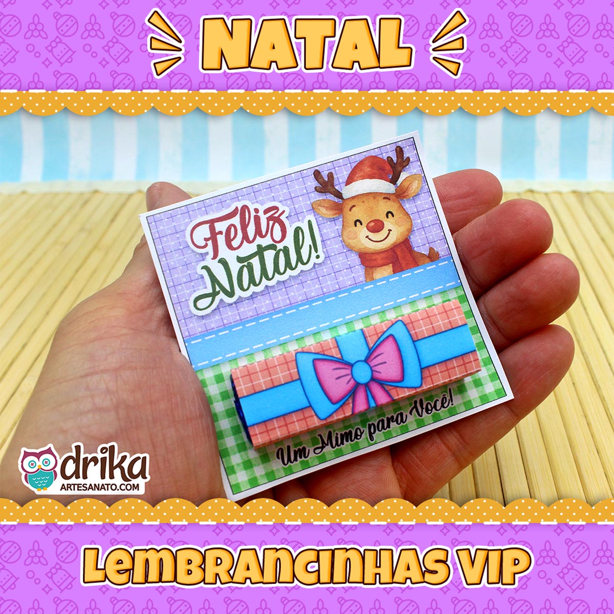 Mão segurando um cartão porta-bis de rena fofa com gorro de Papai Noel e laço rosa, com banner "Lembrancinhas VIP"
