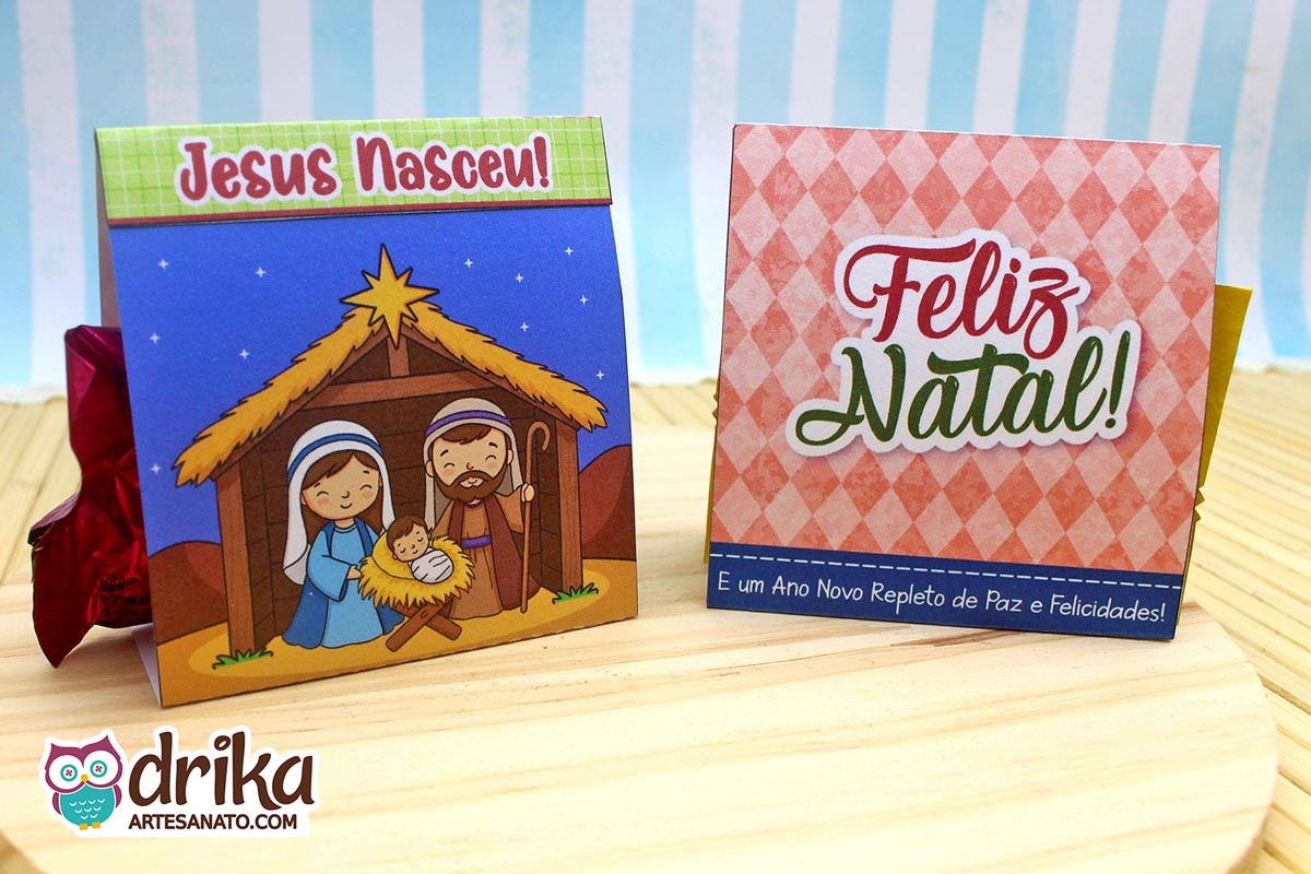 Dois porta-bombons de Natal lado a lado: um com a Sagrada Família e outro com mensagem de Feliz Natal.
