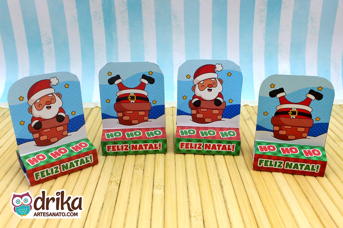 Quatro porta-bis duplos de papel com dois modelos de Papai Noel na chaminé, alinhados em uma mesa de madeira