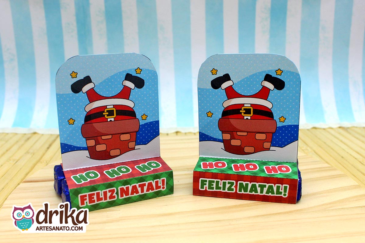 Dois porta-bis duplos de papel com Papai Noel de pernas para o ar em chaminé, com base verde, lado a lado