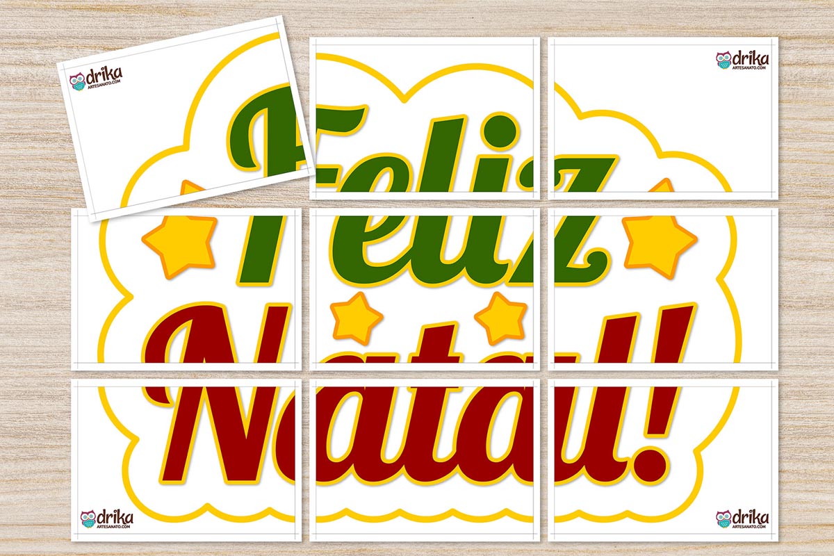 Nove folhas A4 brancas com partes do painel "Feliz Natal!" em verde e vermelho, estrelas amarelas e moldura de nuvem dourada, dispostas sobre madeira clara