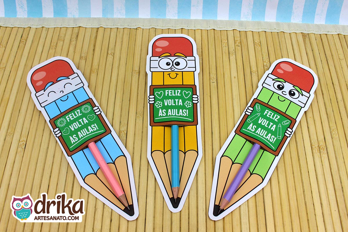 Três cartões porta-lápis gigantes de meninos (azul, amarelo, verde) com lápis de cor inseridos
