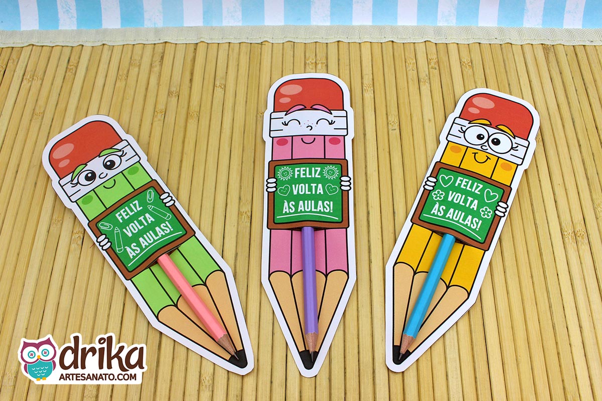 Três cartões porta-lápis gigantes de meninas, nas cores verde, rosa e amarelo, com lápis de verdade encaixados