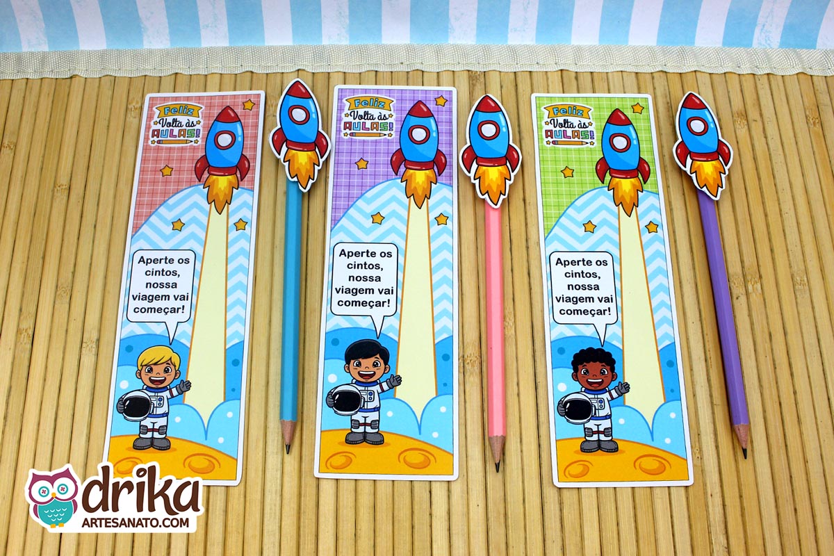 Três cartões porta-lápis de astronautas meninos, com lápis coloridos e foguetes 3D, sobre um fundo de bambu