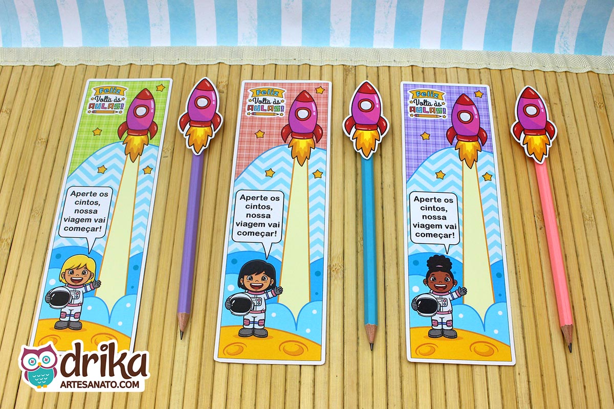 Três cartões porta-lápis de Volta às Aulas com meninas astronautas e foguetes em lápis coloridos, sobre fundo de madeira