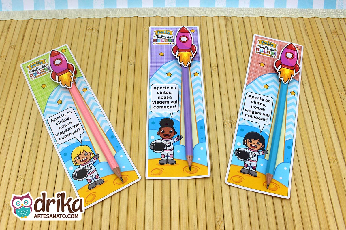 Três cartões porta-lápis com meninas astronautas de cabelos diferentes, lápis coloridos e foguetes