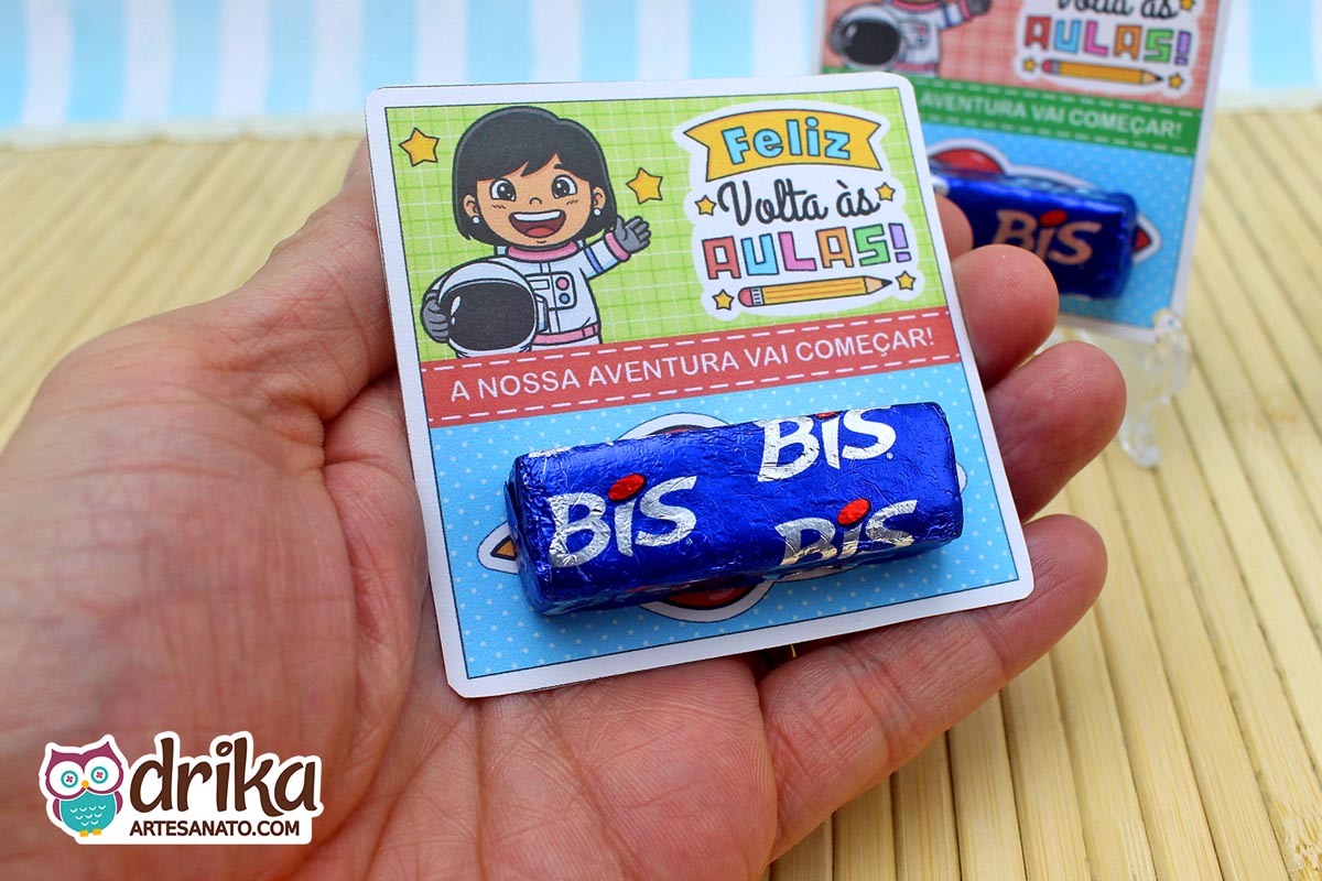 Mão segurando cartão porta-bis com menina astronauta de cabelo preto e bis de chocolate, sem foguete 3D