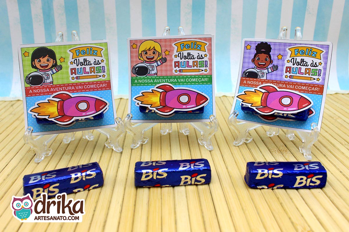 Três cartões porta-bis de astronautas meninas (cabelo preto, loira, crespo) com foguetes 3D e bis