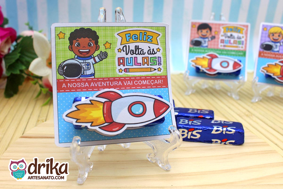 Cartão porta-bis de astronauta menino com cabelo crespo, bis azul e foguete 3D colado, em suporte transparente