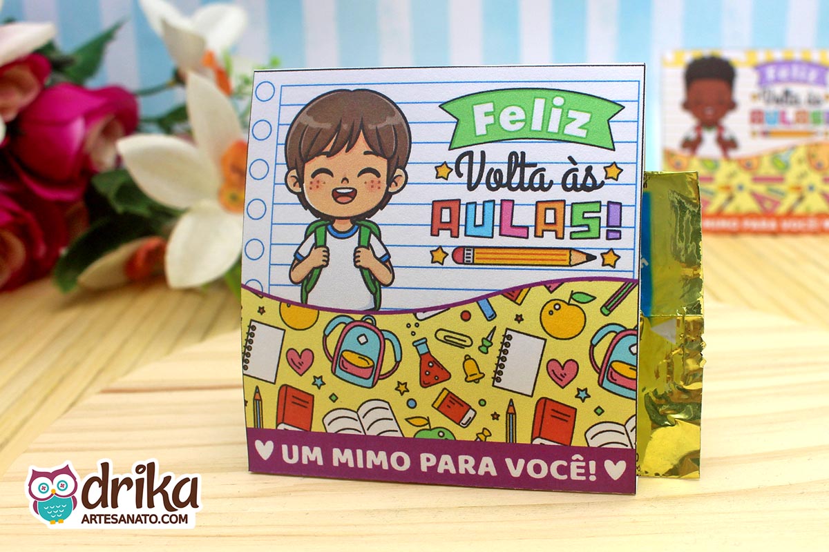 Porta-bombom de papel com menino de cabelo castanho liso e mochila, em fundo de caderno. Decorado com mochilas e livros
