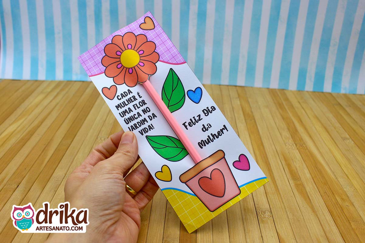 Cartão porta-lápis de Dia da Mulher com flor laranja, lápis rosa como caule e fundo xadrez
