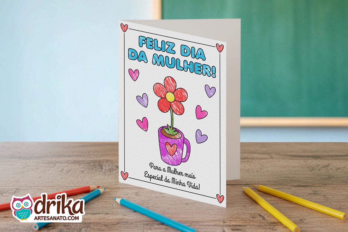 Cartão de Dia da Mulher colorido com flor vermelha em caneca roxa, corações e a frase "Feliz Dia da Mulher!" sobre mesa de madeira com lápis