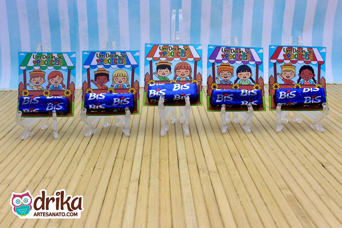 Cinco porta-bis caipiras cute com casais de crianças diferentes, cada um com dois chocolates Bis azuis, alinhados em expositores
