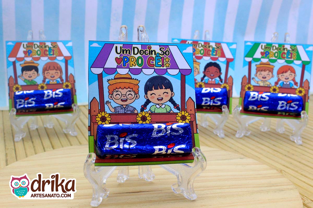 Quatro lembrancinhas Porta-bis Caipiras Cute com chocolates Bis em suportes transparentes. O modelo em primeiro plano mostra um menino ruivo de óculos e uma menina de cabelo preto.