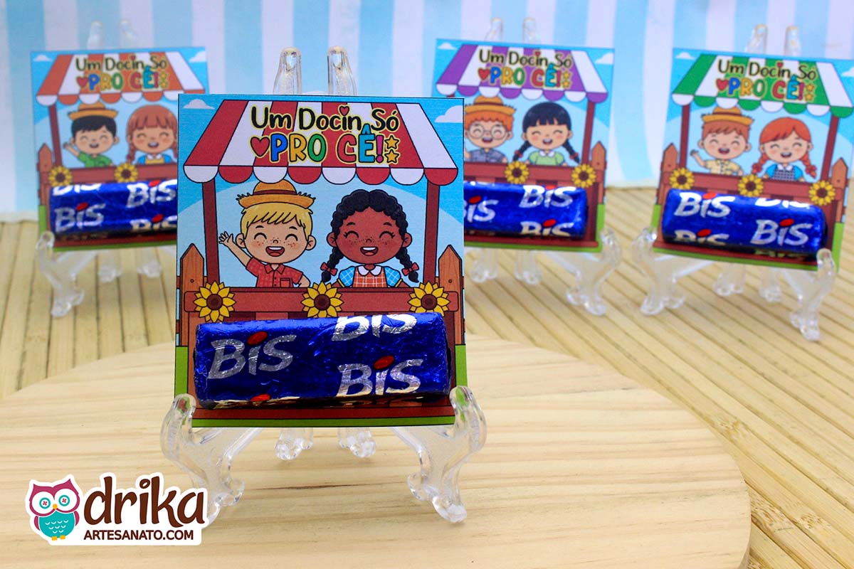 Quatro lembrancinhas Porta-bis Caipiras Cute com chocolates Bis em suportes transparentes. O modelo em destaque tem um menino loiro e uma menina de cabelo crespo.
